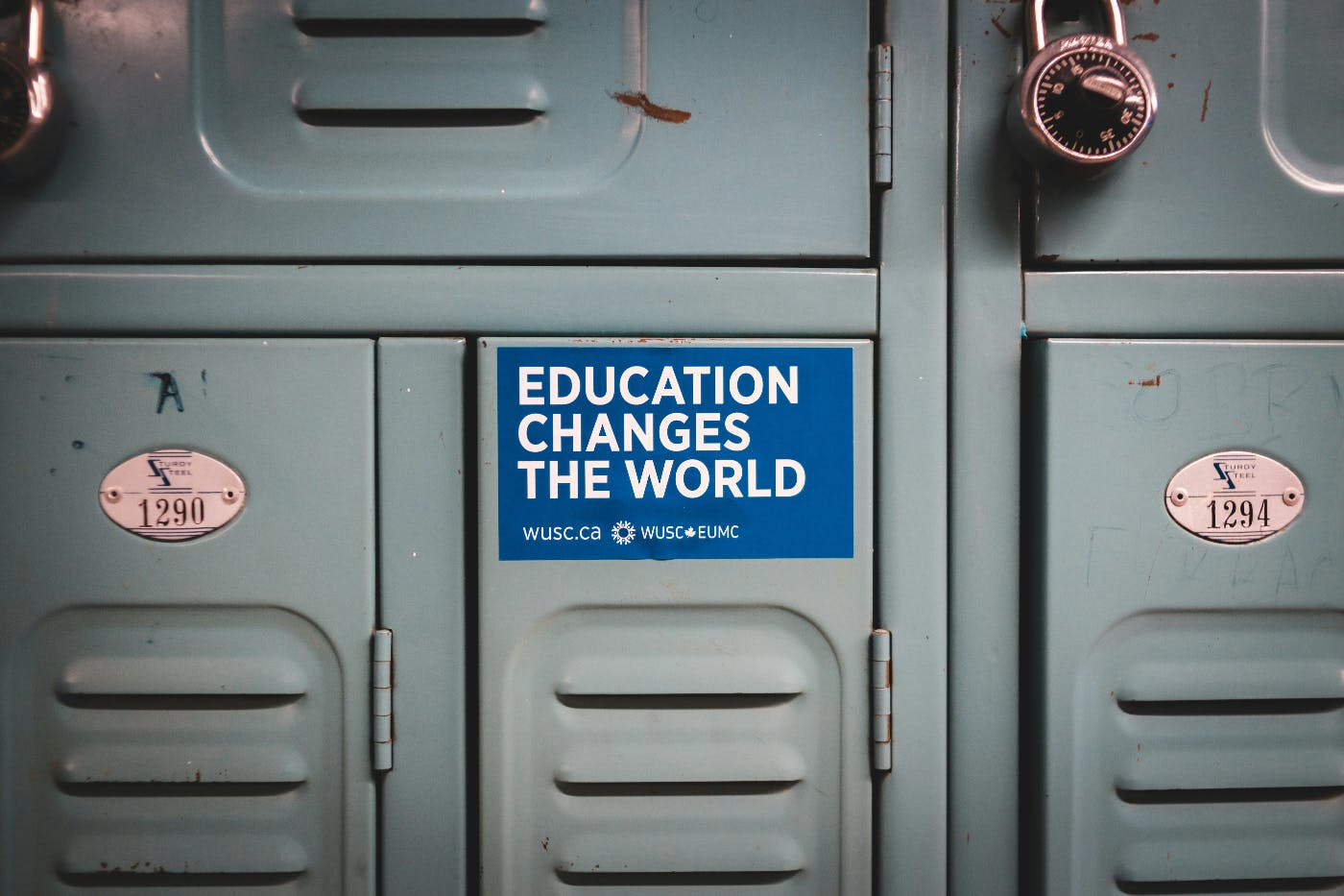 A bank of gray lockers one with a sticker reading Education Changes The World