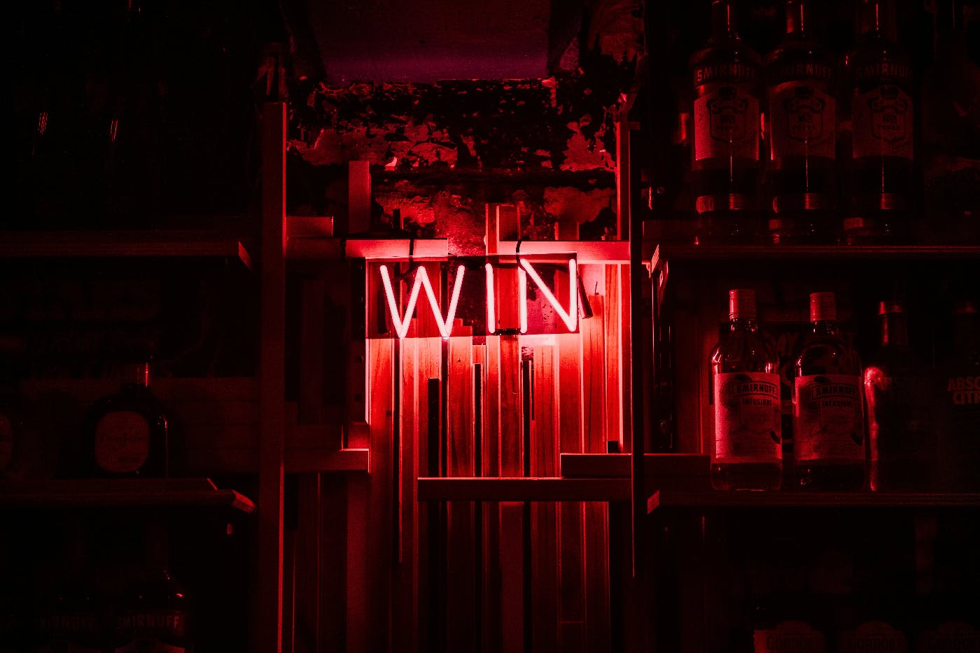 A red neon sign behind a bar reading WIN