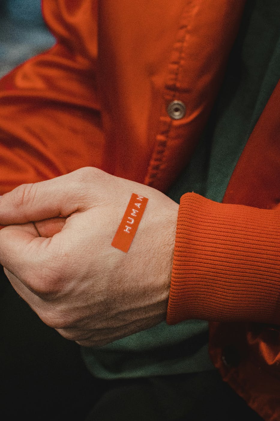 A person in an orange jacket with an orange label not heir had reading human