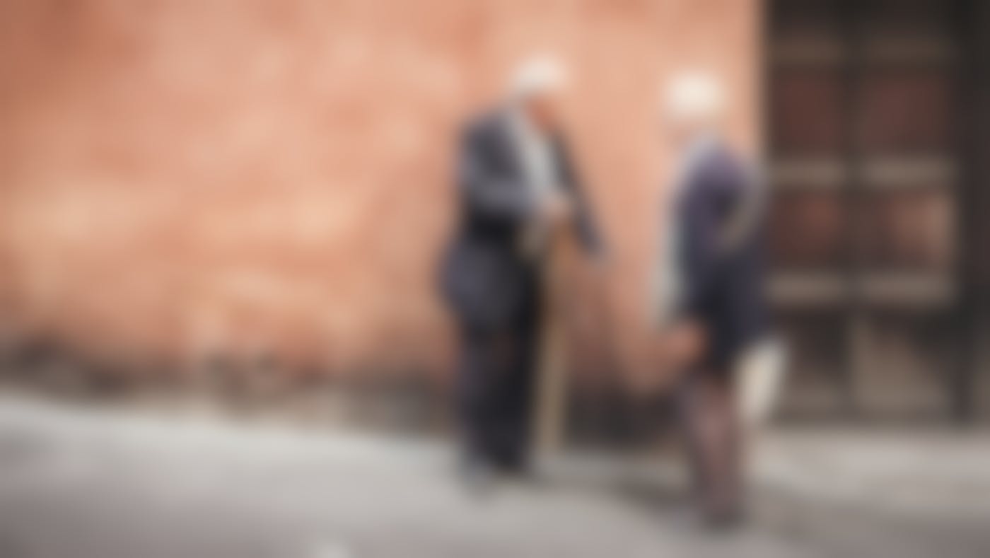 An older couple having a conversation on a street in Italy