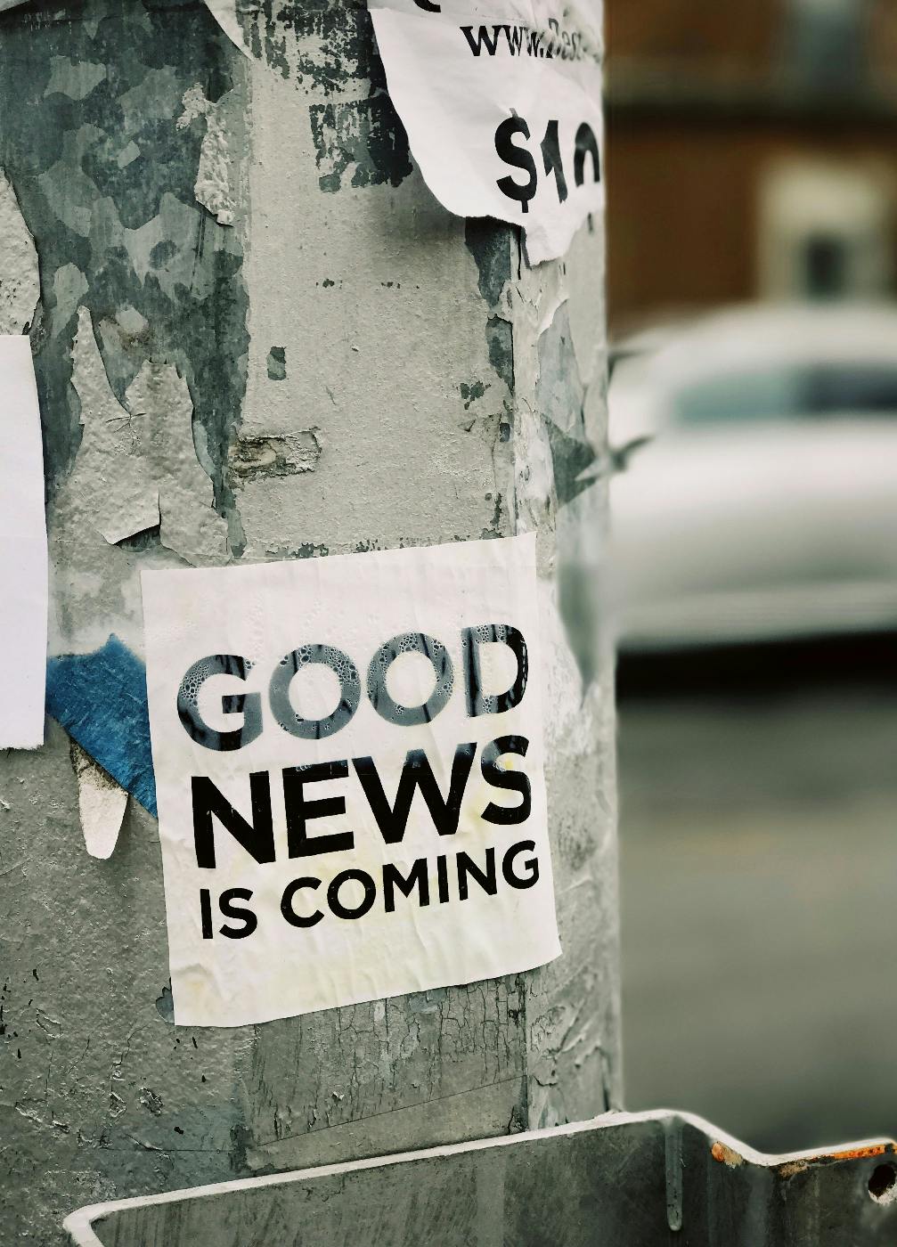 A pole with a sign reading Good News Is Coming