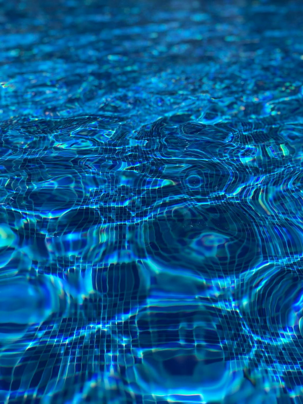 Clear blue water gently rolling in a pool