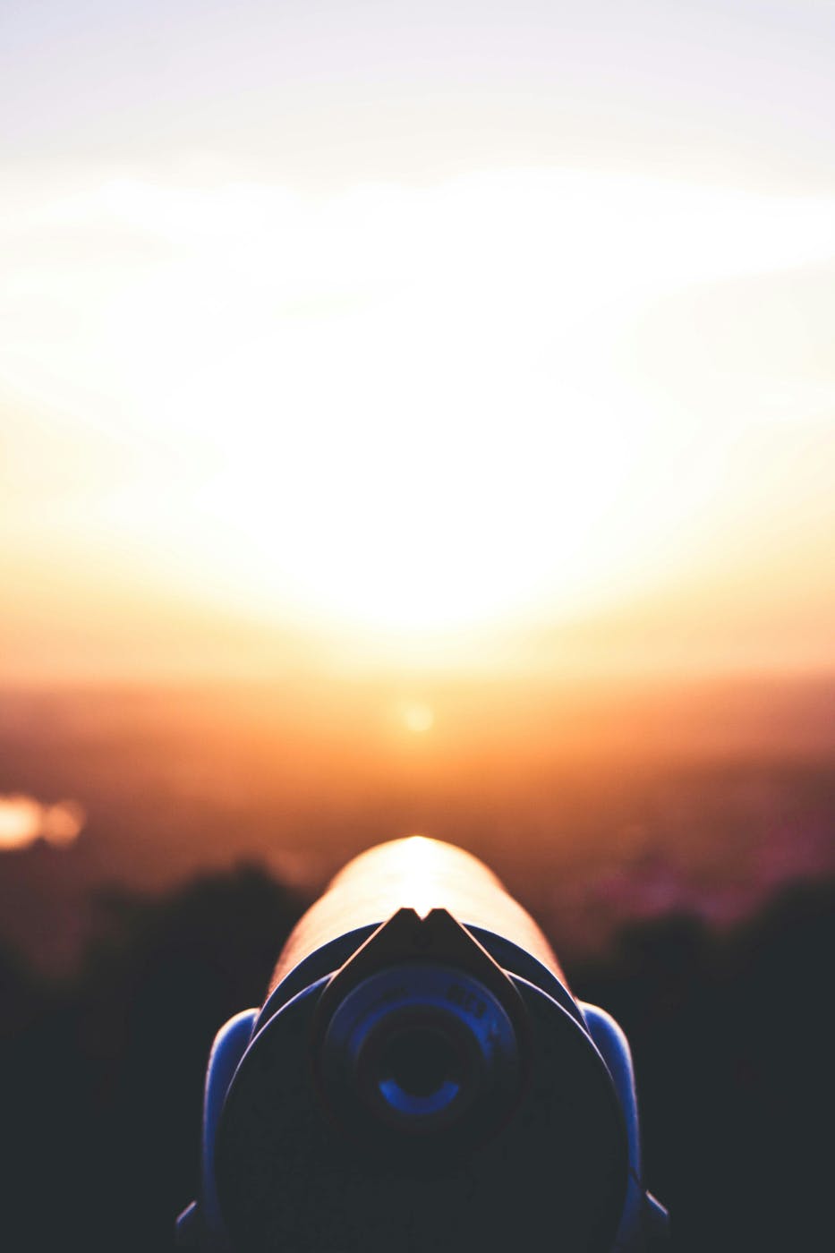 A sight scope looking at a sunrise