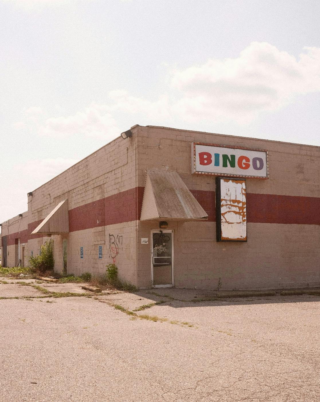 A broken down building with a neon sign on the side announcing BINGO