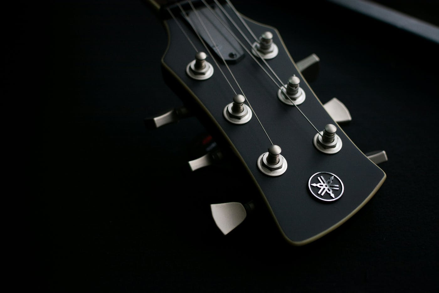 close up of a guitar neck on a black background