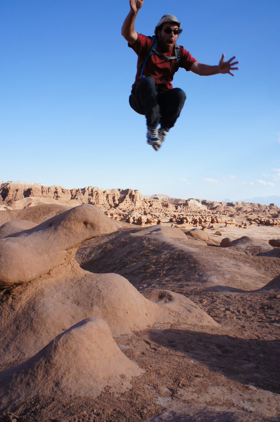 A man jumping high in the air over deserts sands