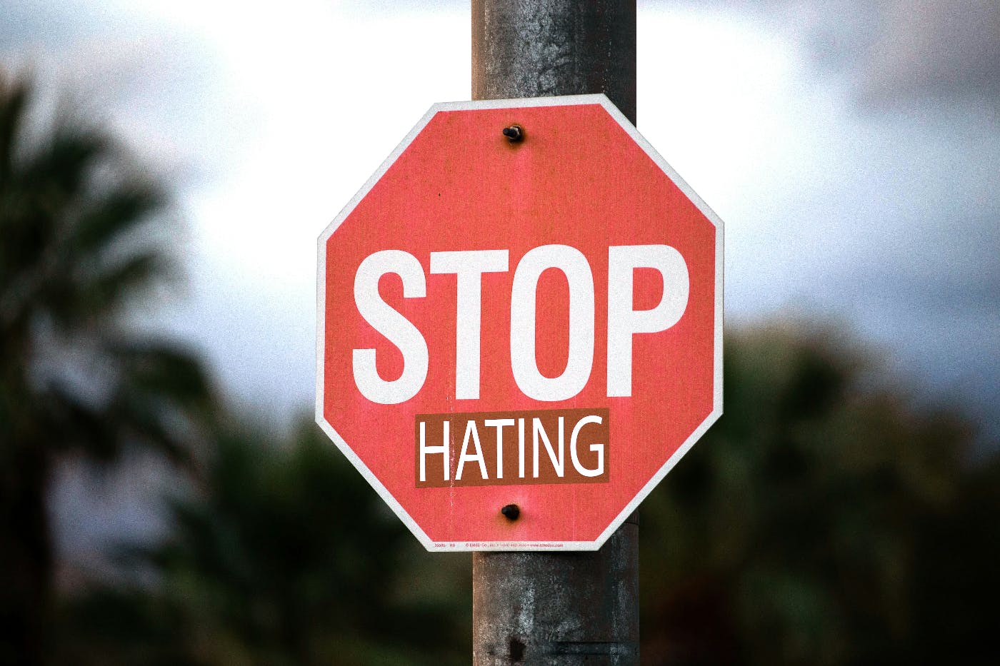 A stop sign with the word hating added under the word stop