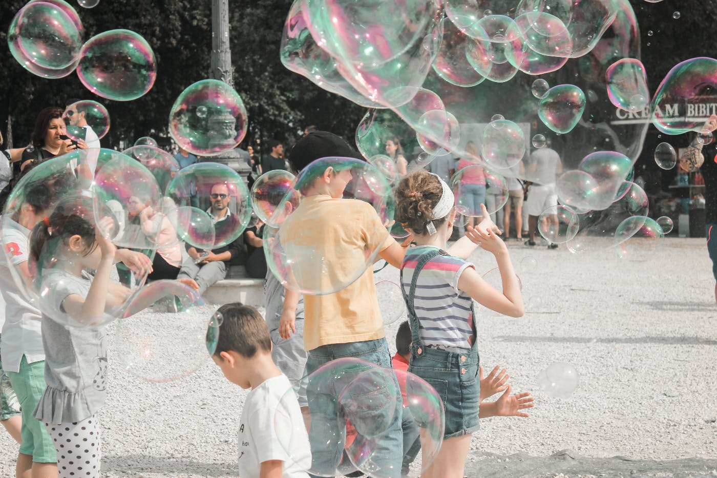 people in a park playing with giant soap bubbles