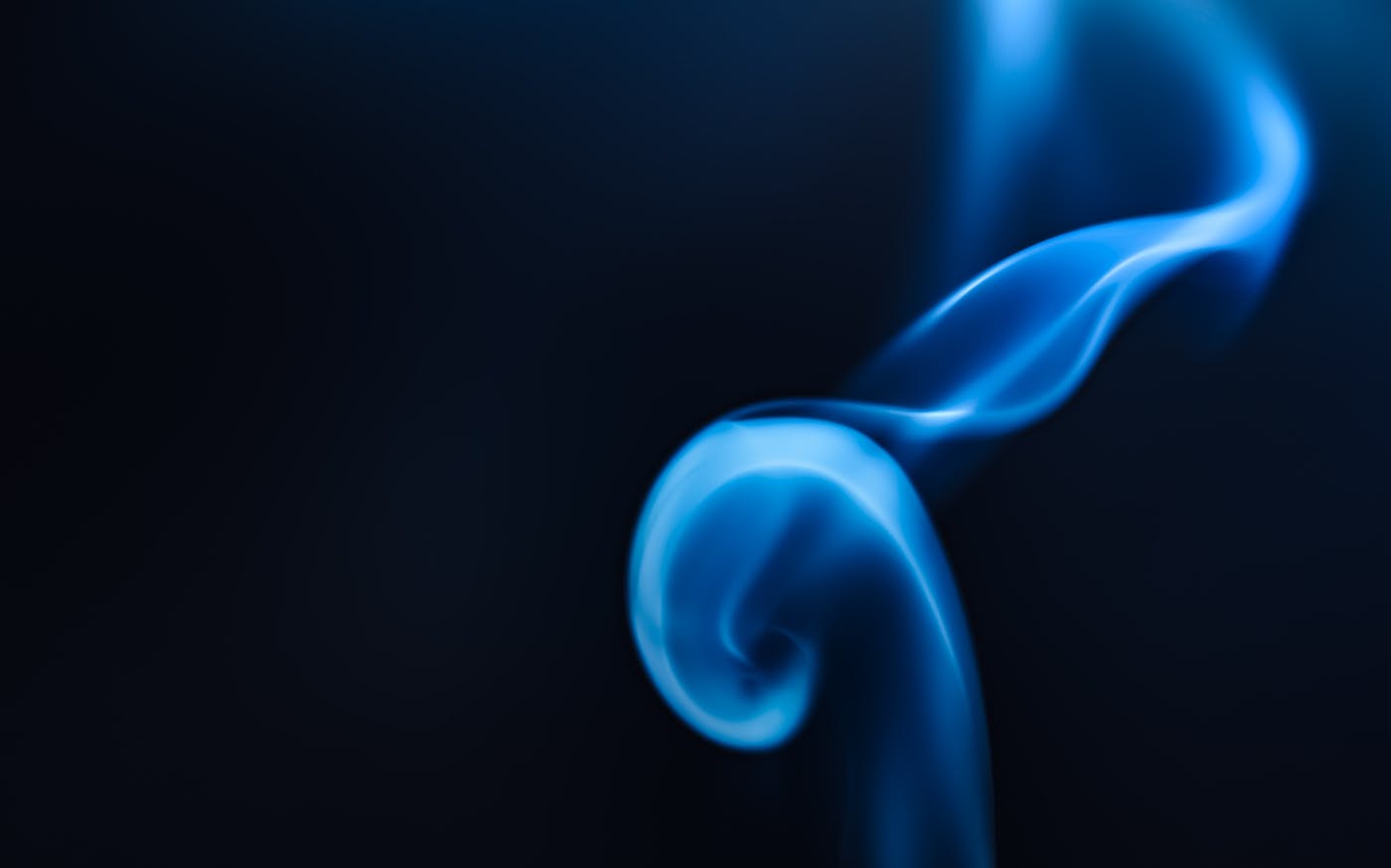 Blue smoke against a black background