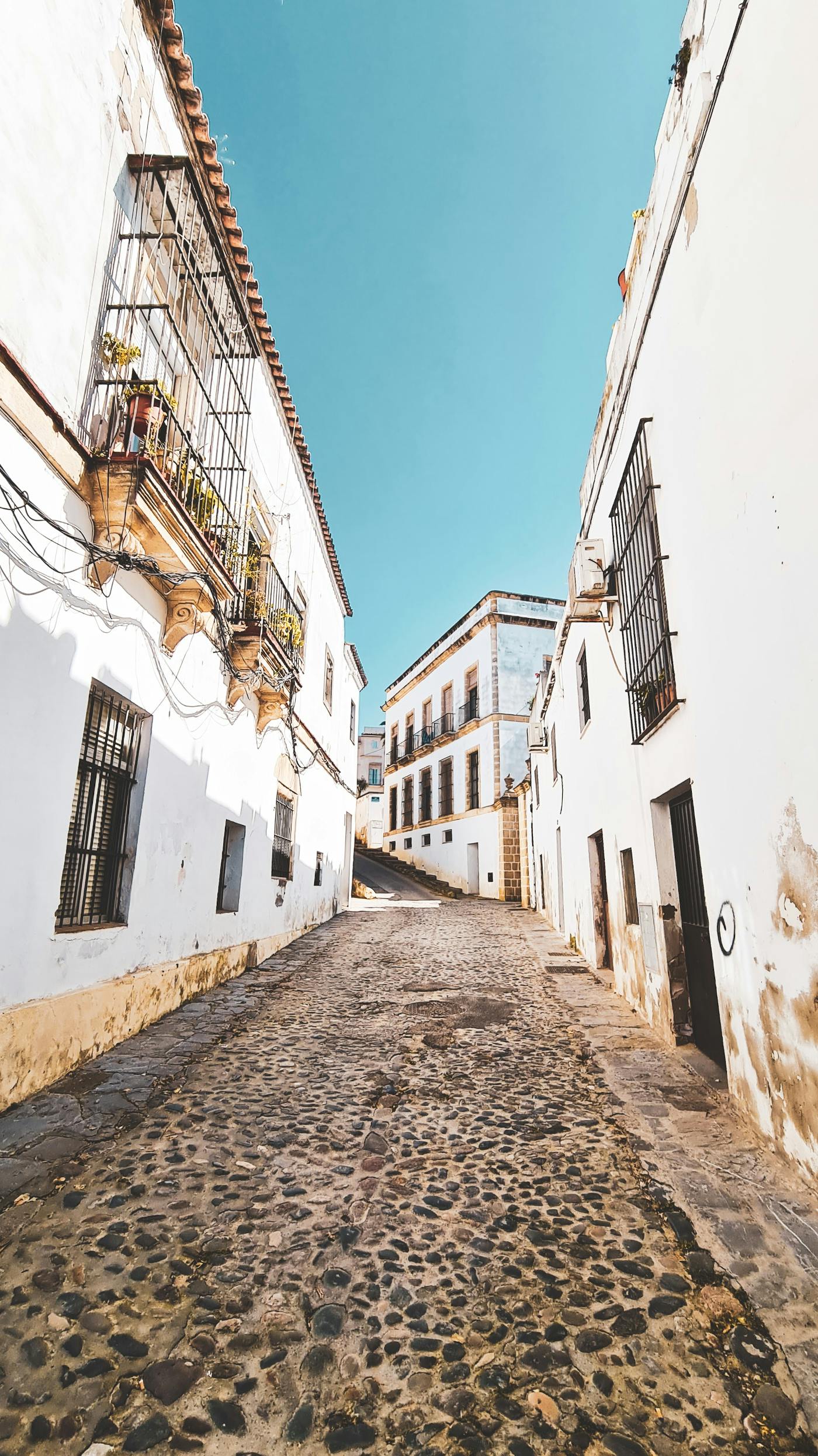 White buildings on eith side of a stone street