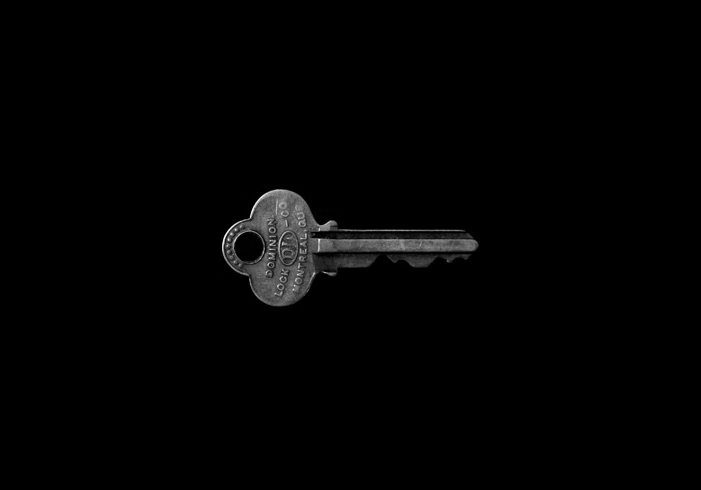 A silver key floating in blackness