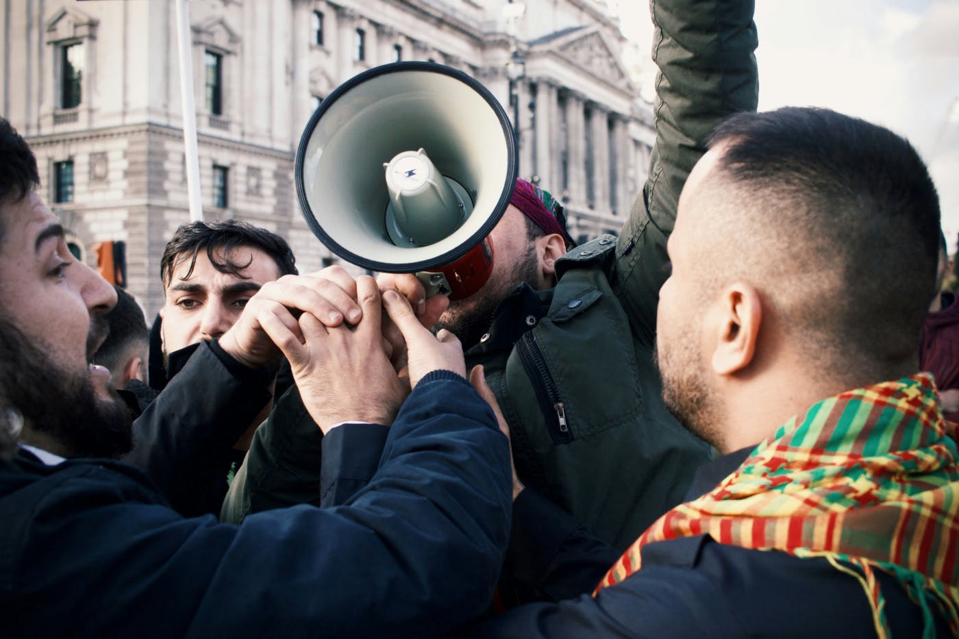 Protester with megaphone being engulfed by a crowd