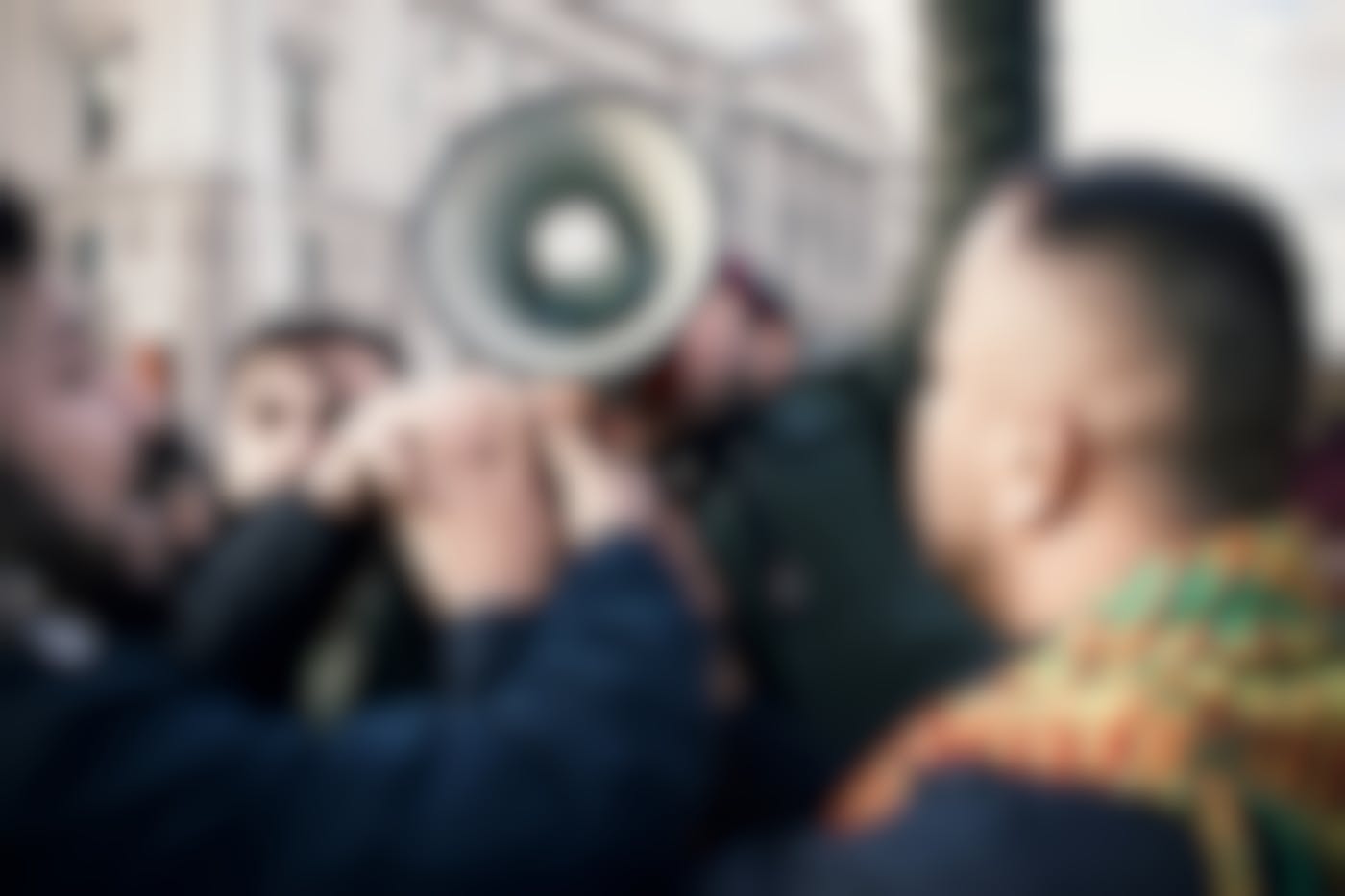 Protester with megaphone being engulfed by a crowd
