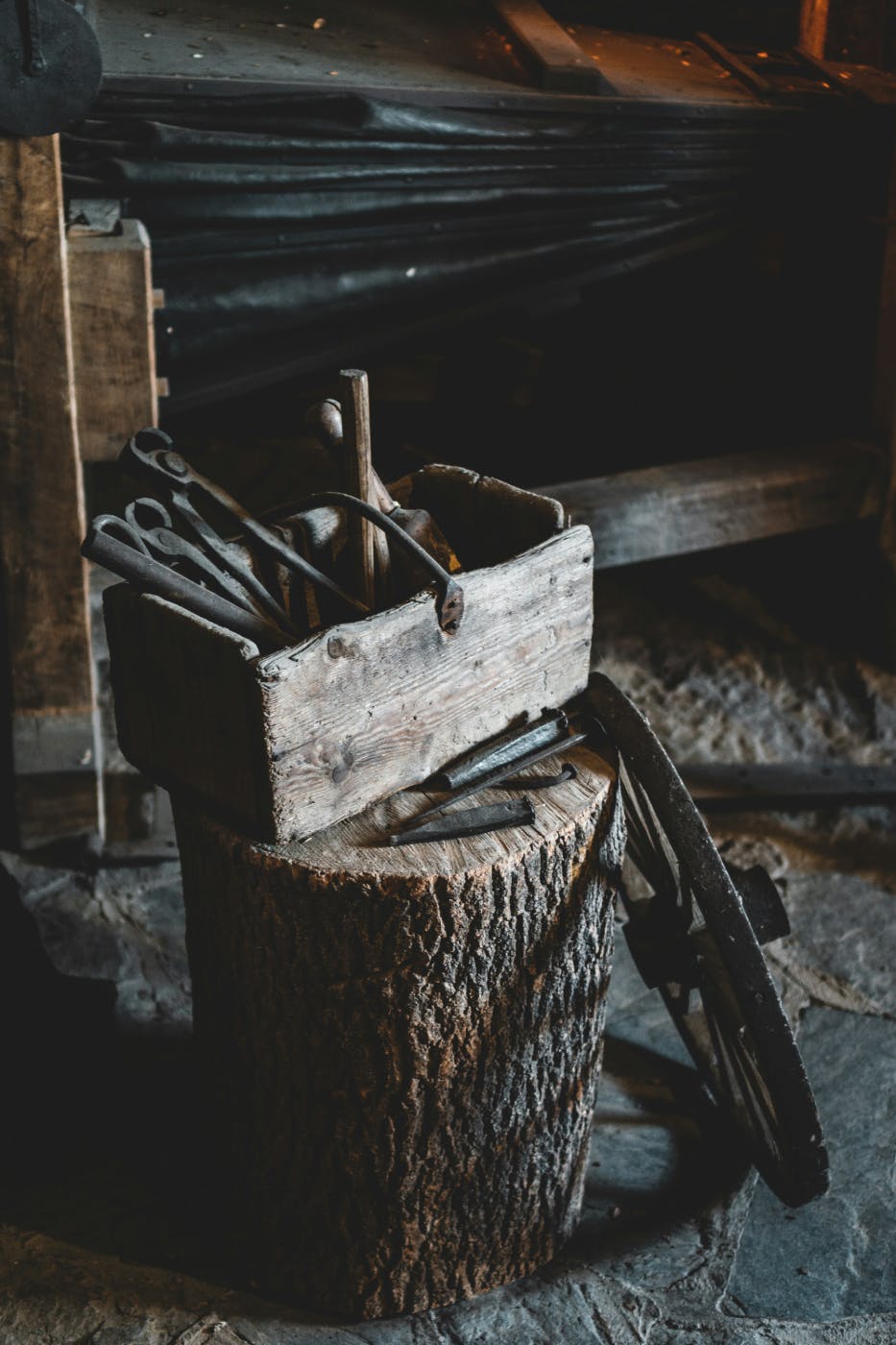 An old, old tool box with tools sitting on a log