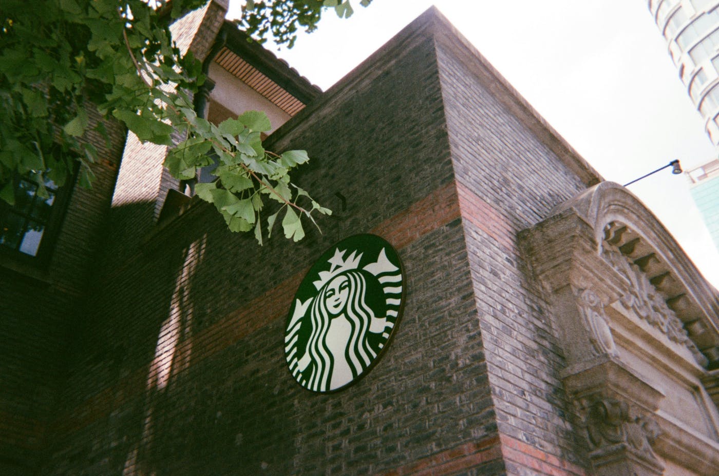 A brick building with a Starbucks Logo n the side
