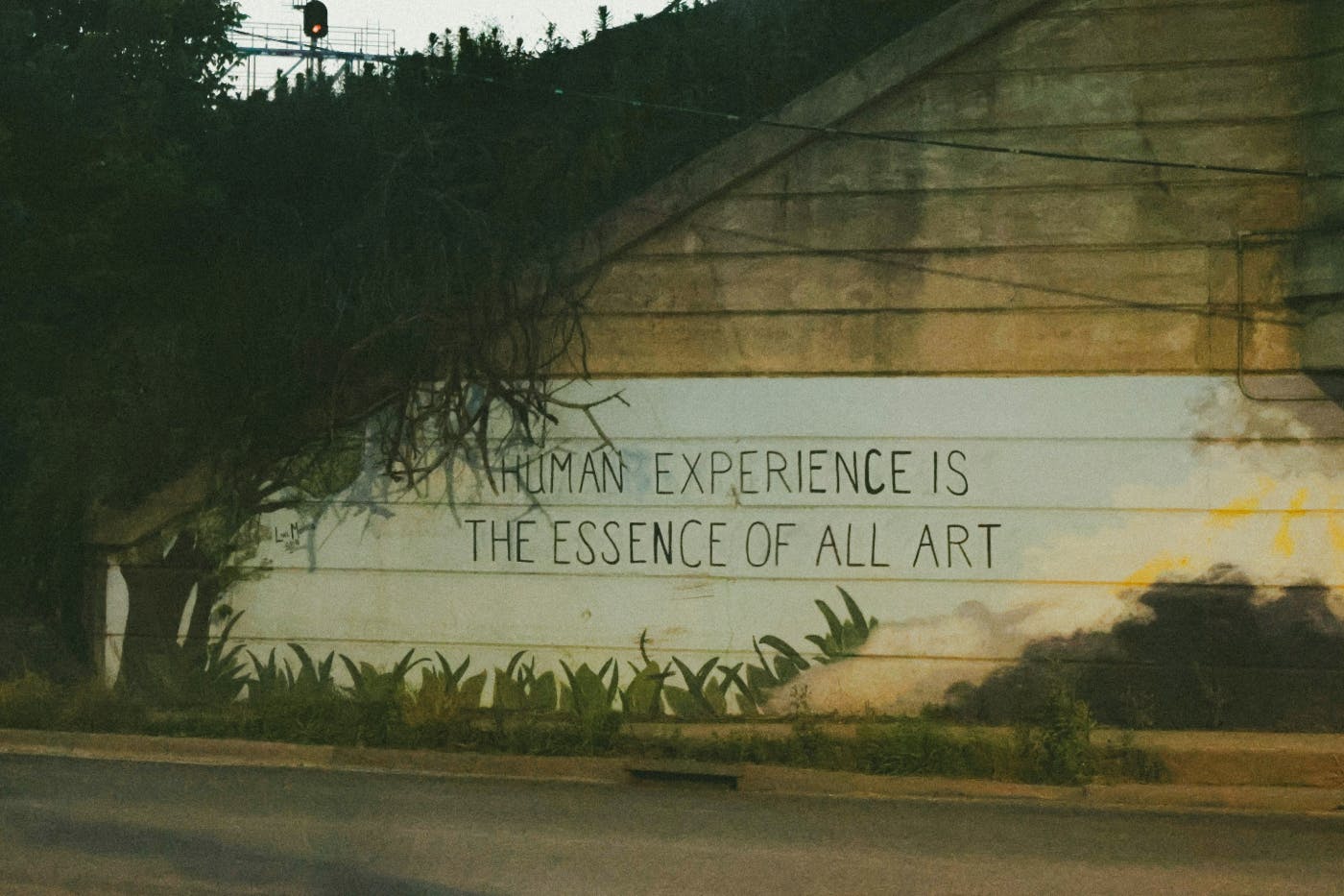 graffiti on a wall reading "Human Experience is the Essence of All Art