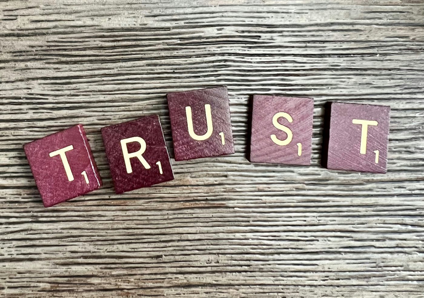 The word Trust spelled out in Scabble tiles
