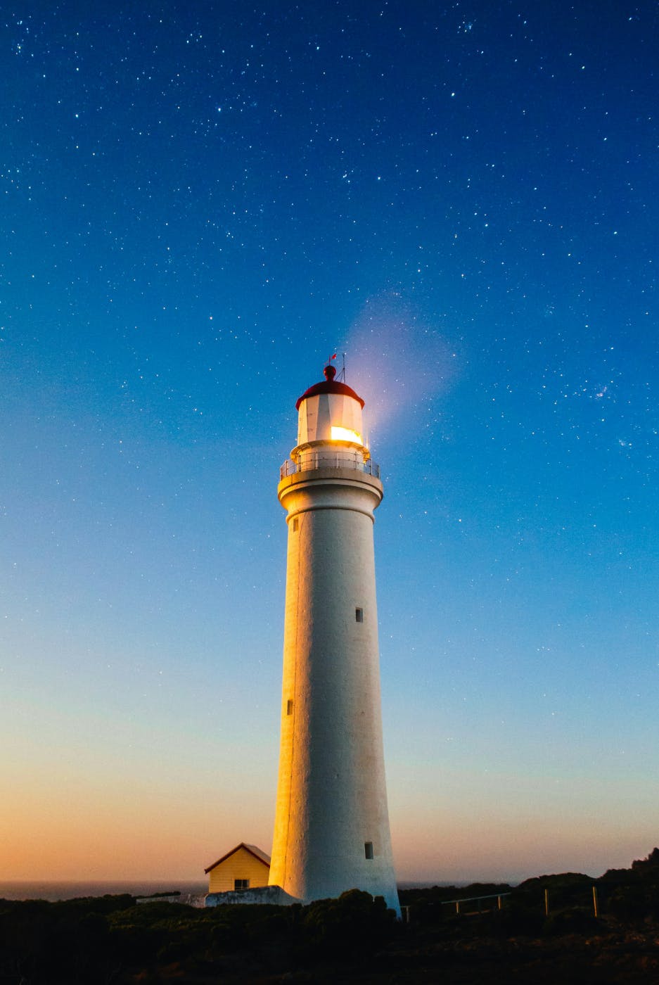 A white lighthouse at dusk