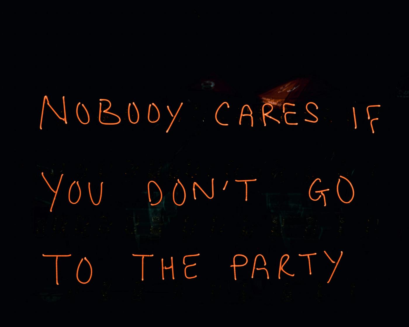 Red letters on a black background reading: Nobody Cares If you Don't Go To The Party