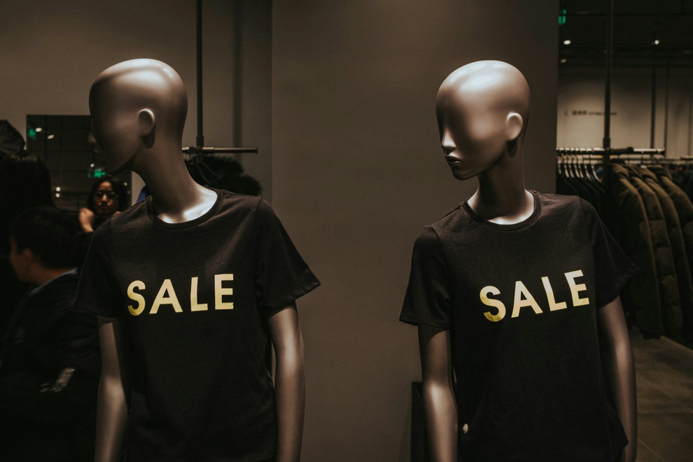 Two mannequins wearing black SALE graphic crew neck Ts