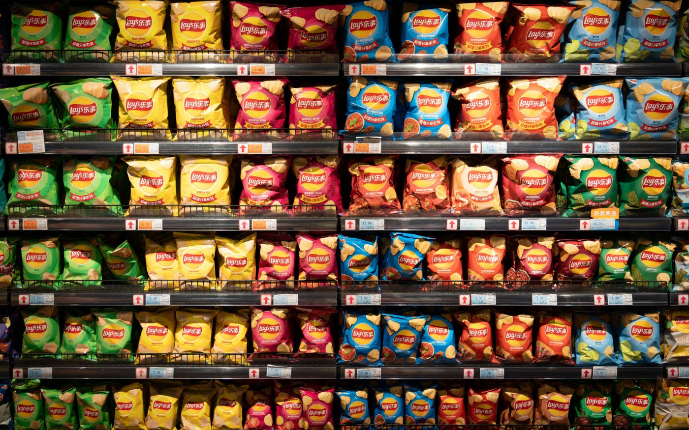 A grocery shelf with hundreds of bags of varieties of Lay's potato chips