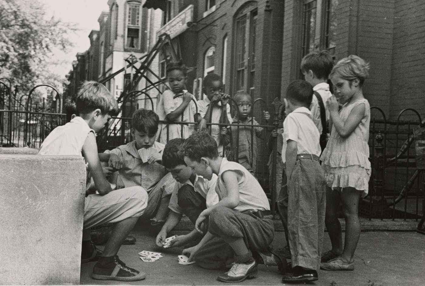 A great scale image on NYC circa 1950's, kids on the street playing cards with others watching