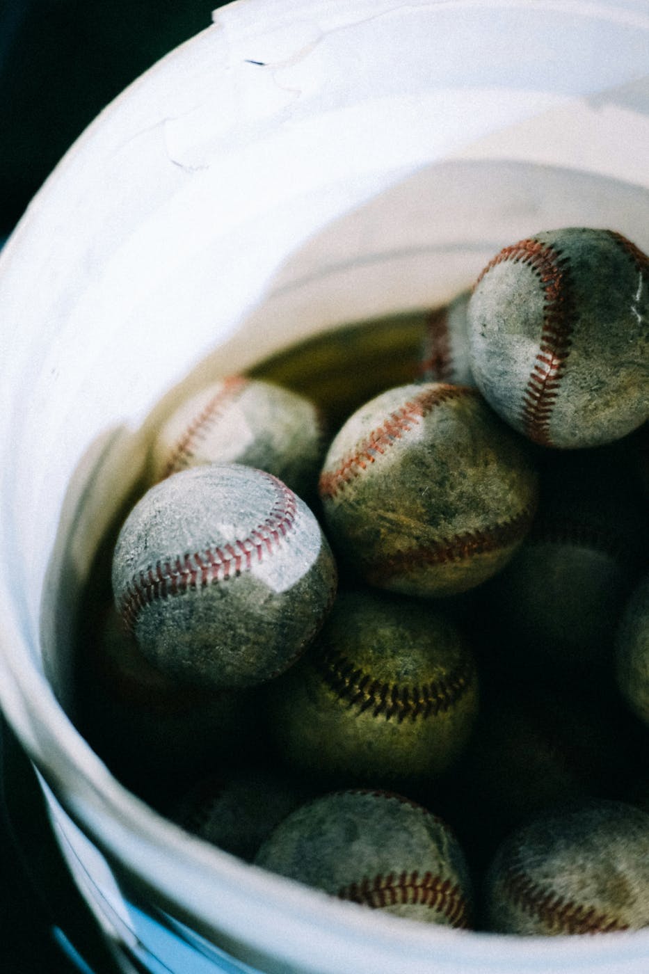 A bucket of worn baseballs