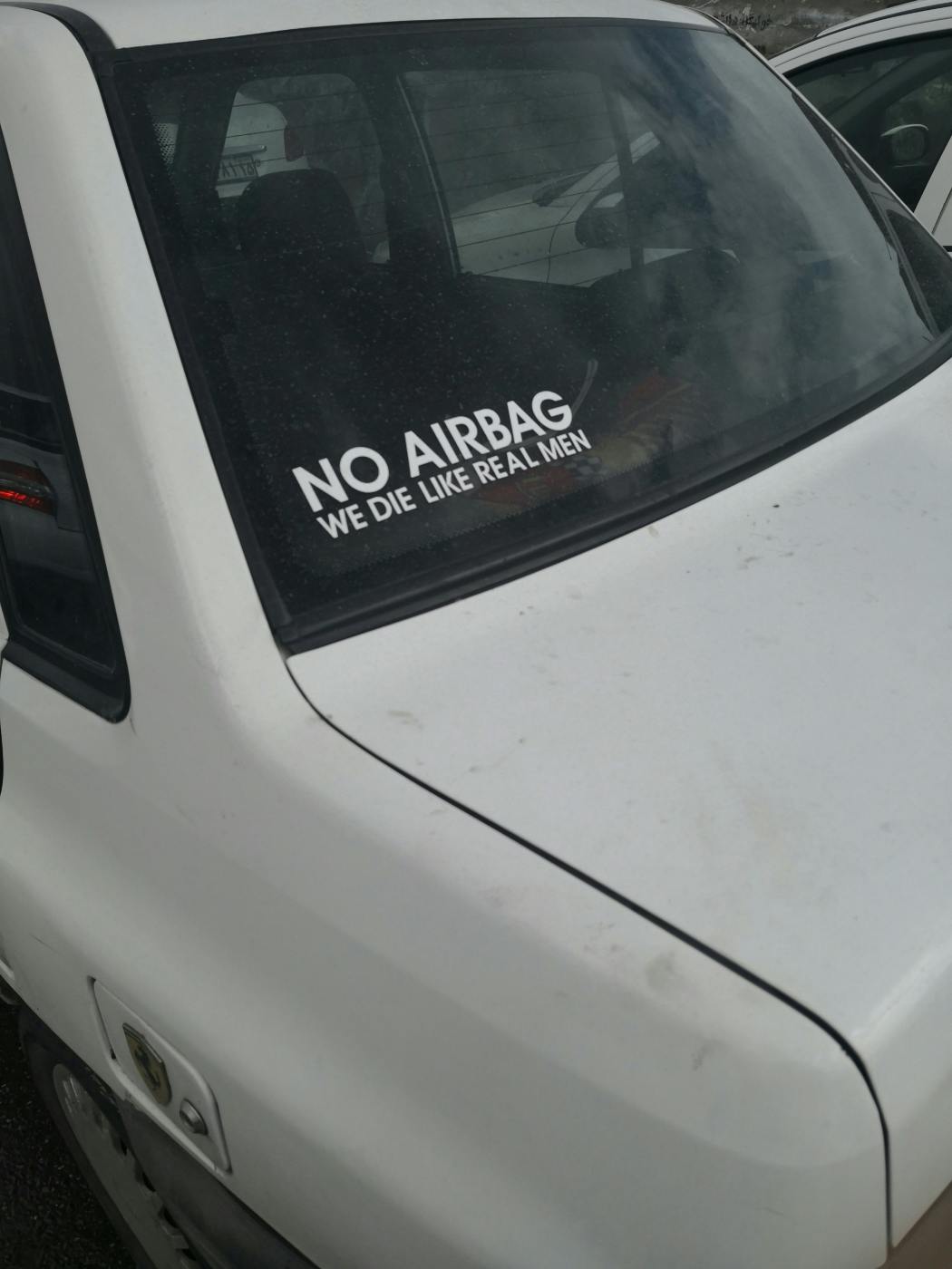 A sticker on a car window reading; No Airbag, We Die Like Real Men
