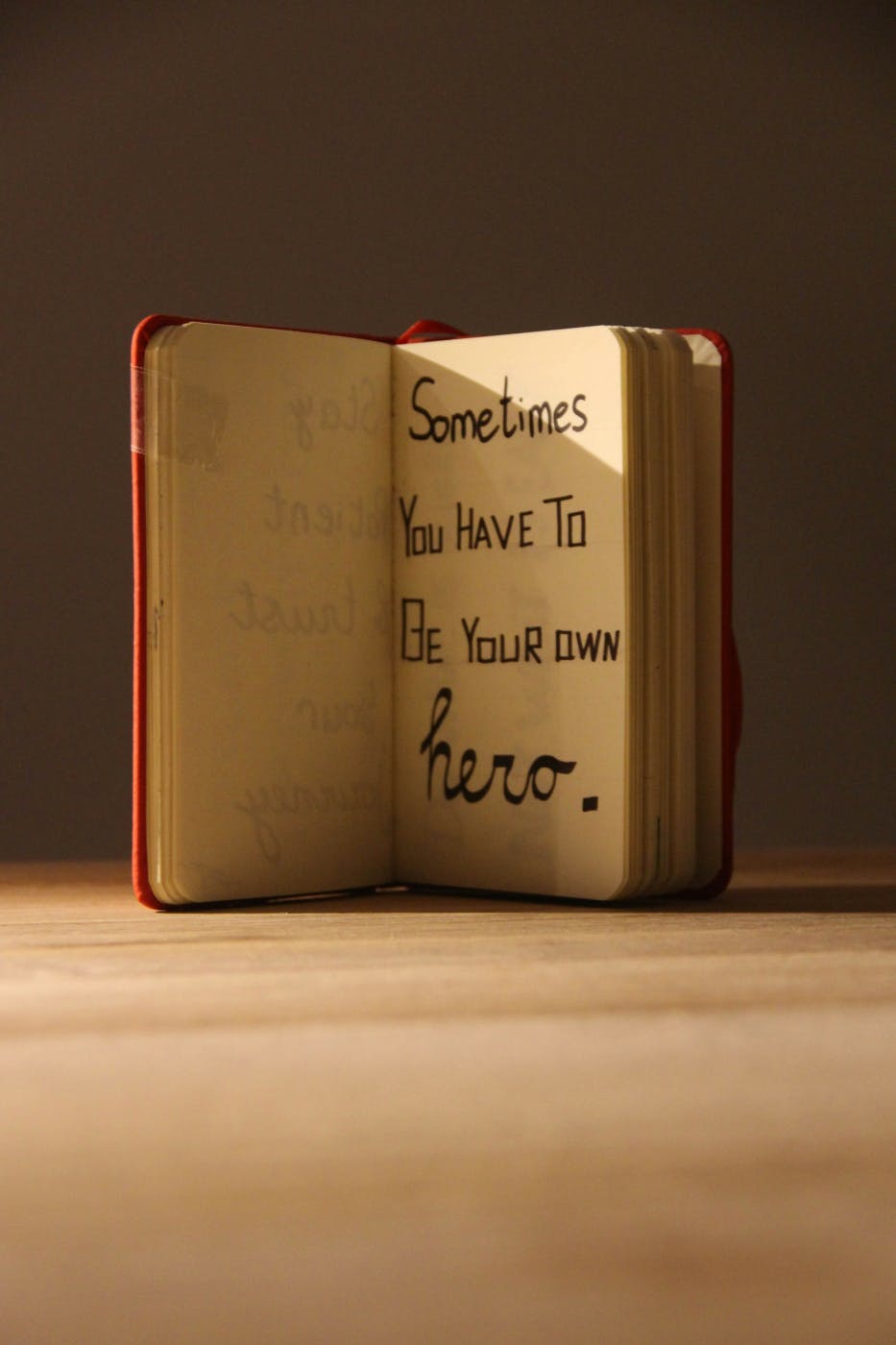 An open journal with a page reading; Sometimes you have to be your own hero