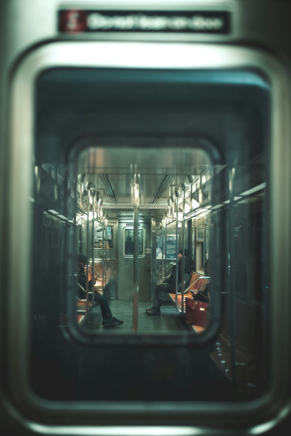 Interior of a subway car with two people riding