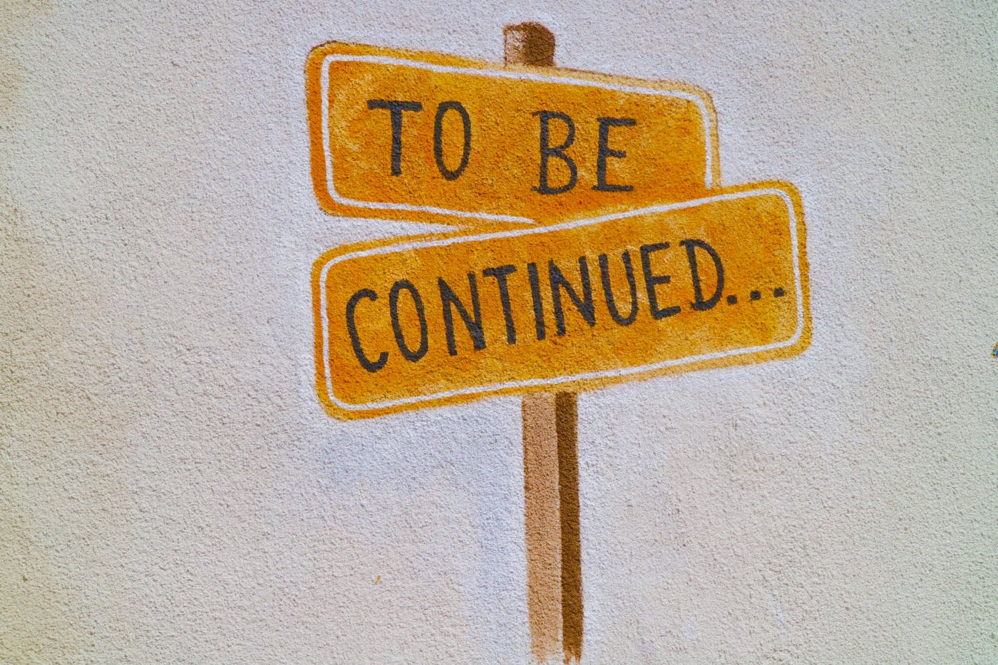 A painting of orange street signs; To Be and Continued