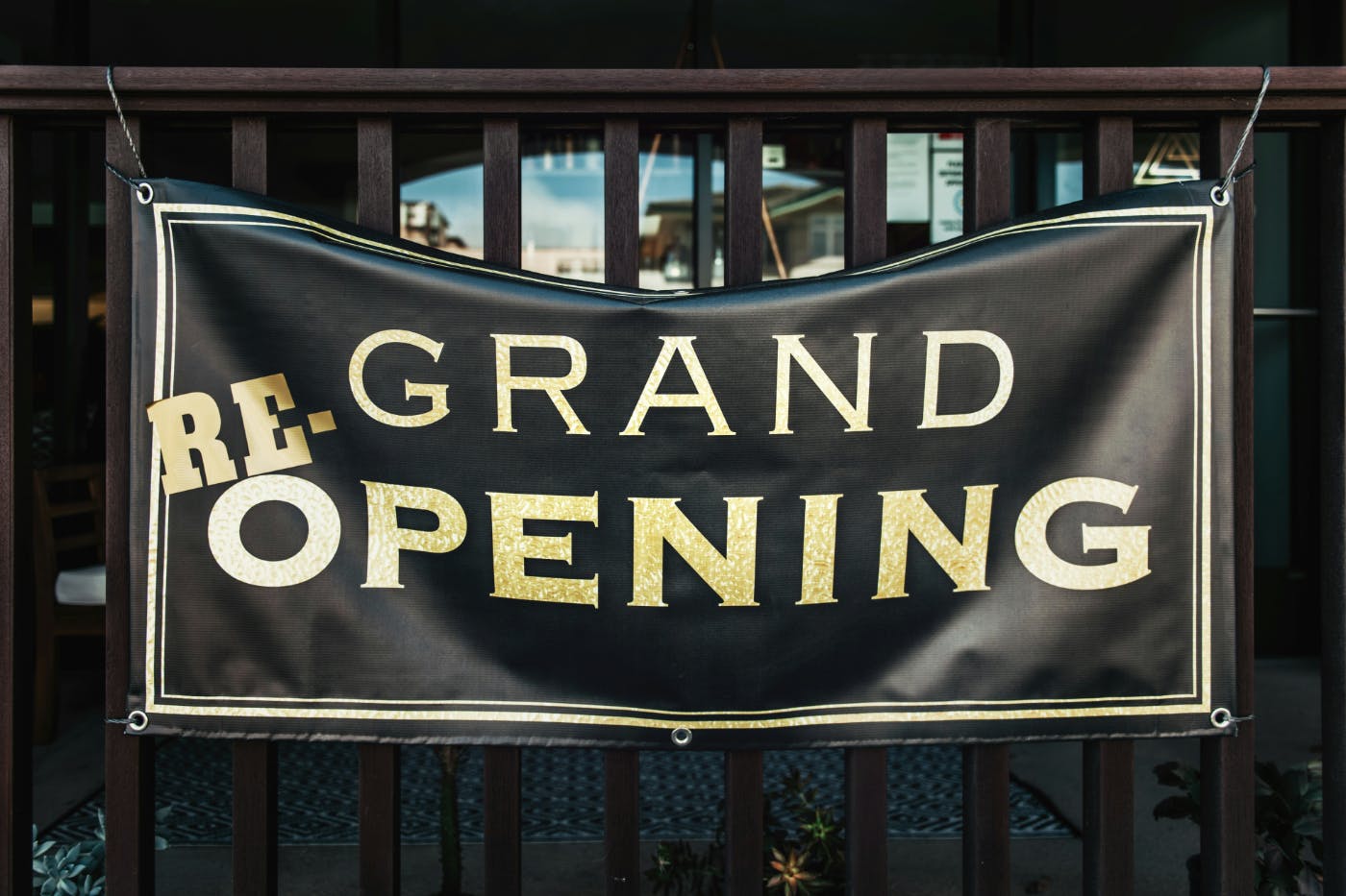 A black banner with gold letters reading: re-grand opening