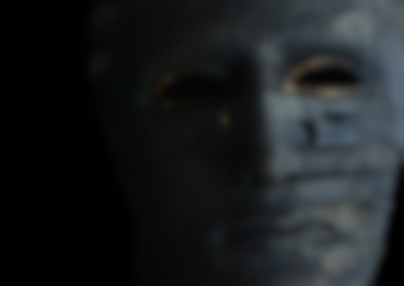 A grey mummy mask with gold painted around the eye holes