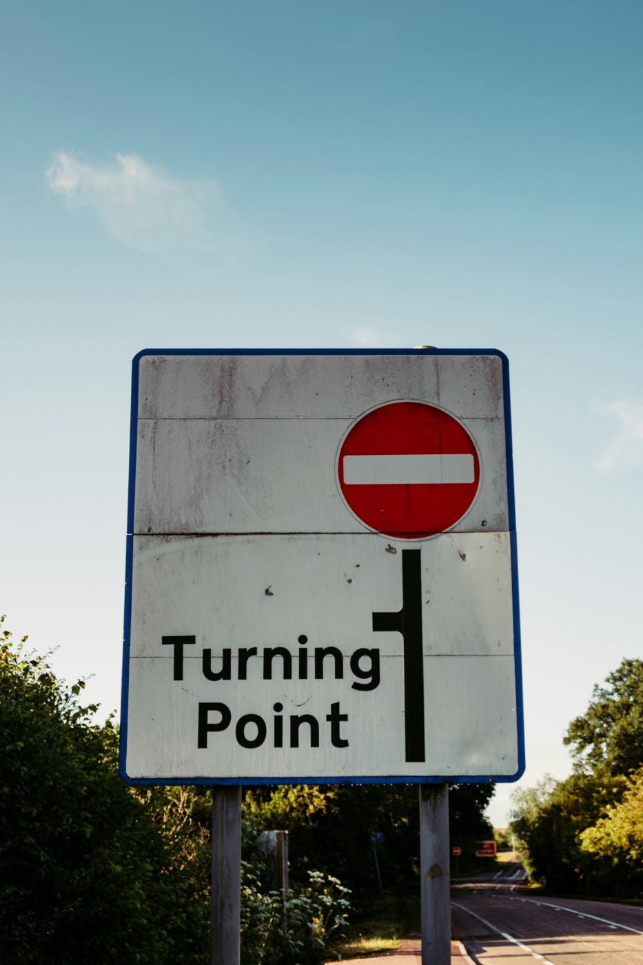 A traffic sign with a red circle and a white line in it with words reading: Turning Point