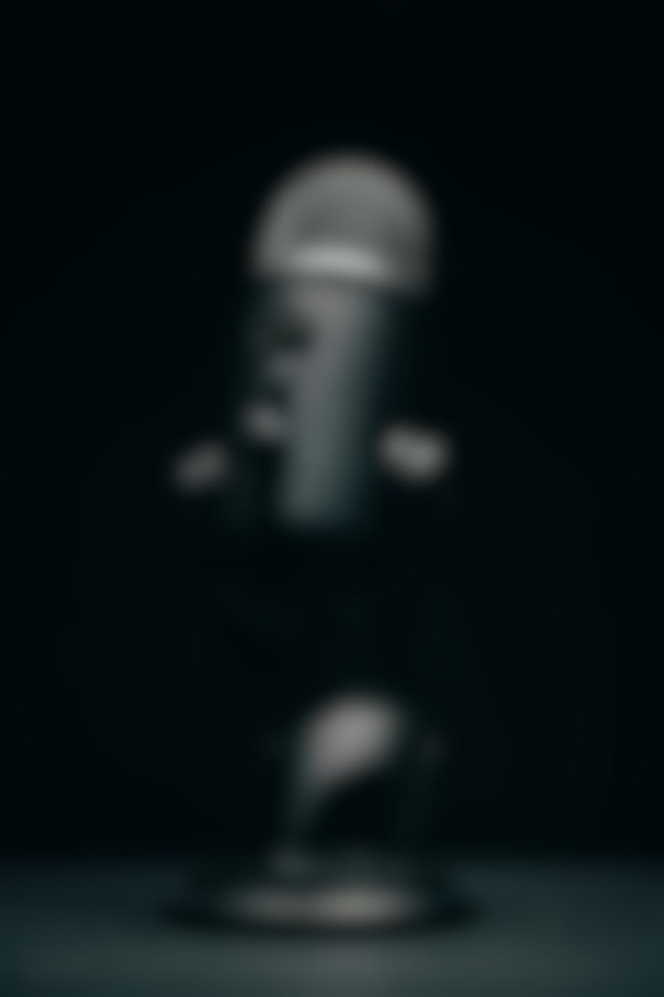 A black microphone on a black table in a dimly lit room