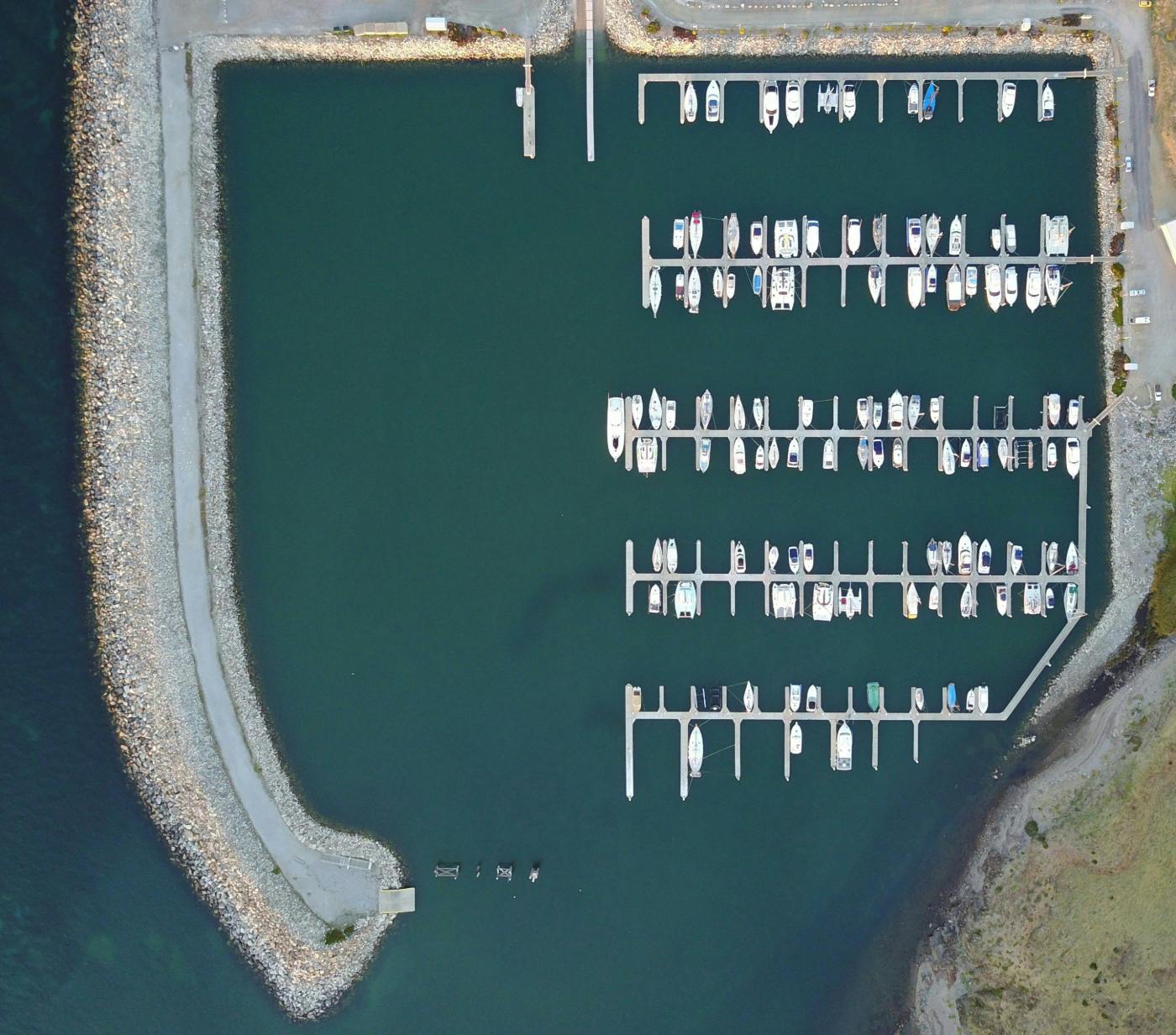 A snug harbor with a marina and an asymmetrical number of boats docked