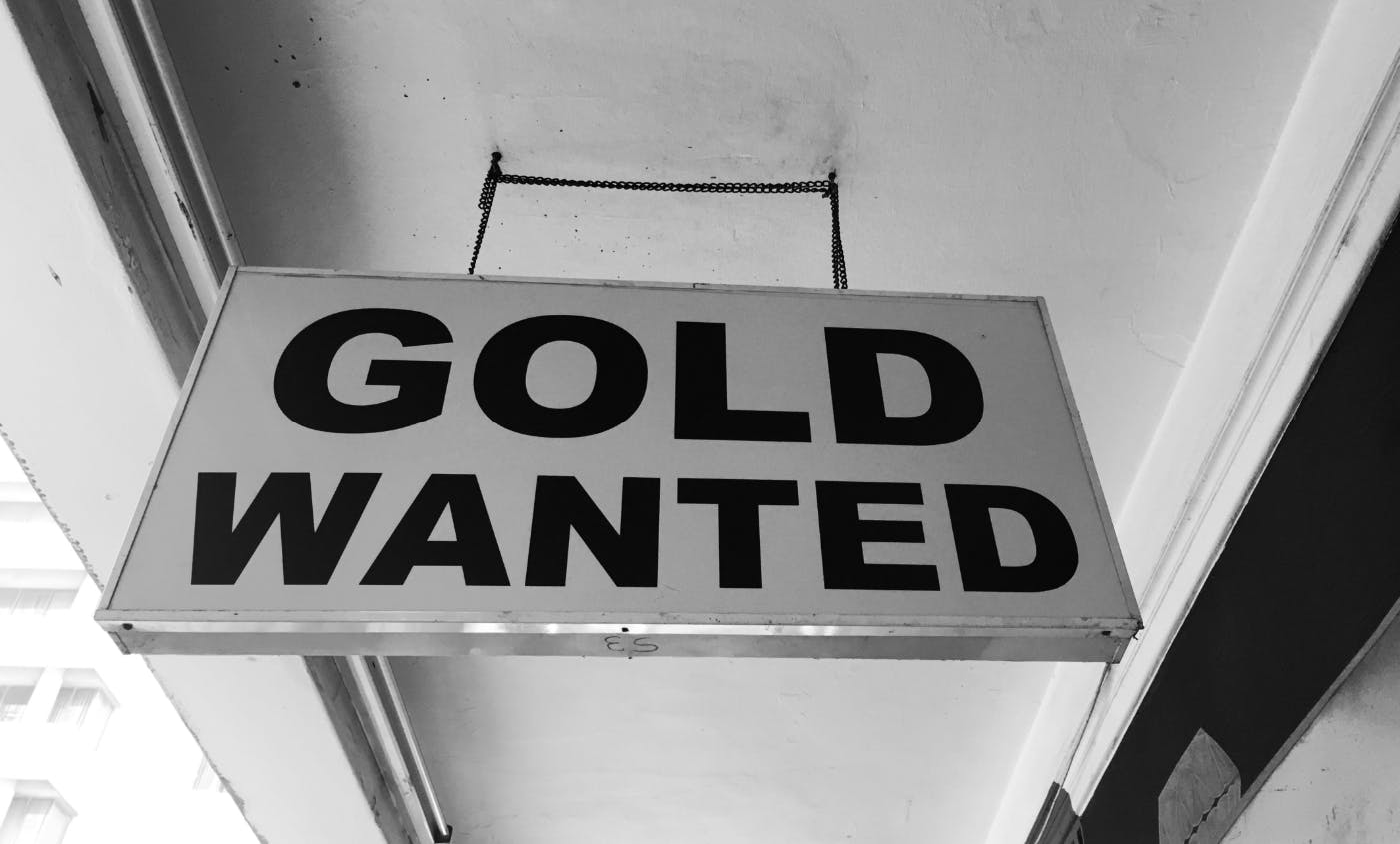 Gray scale photo of a sign reading GOLD WANTED