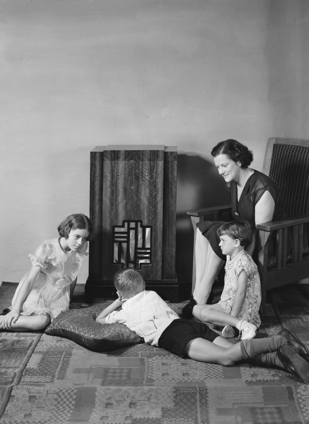 Mom and her three kids gathered around the wireless