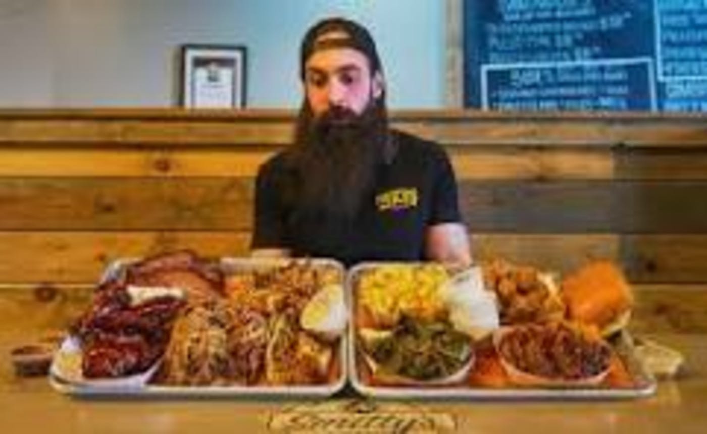 A bearded guy sitting in front of a massive meal