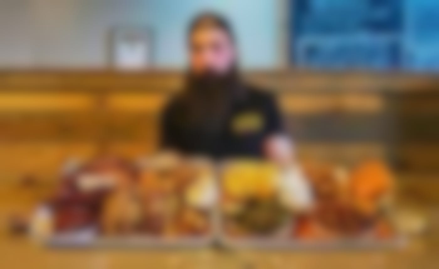 A bearded guy sitting in front of a massive meal