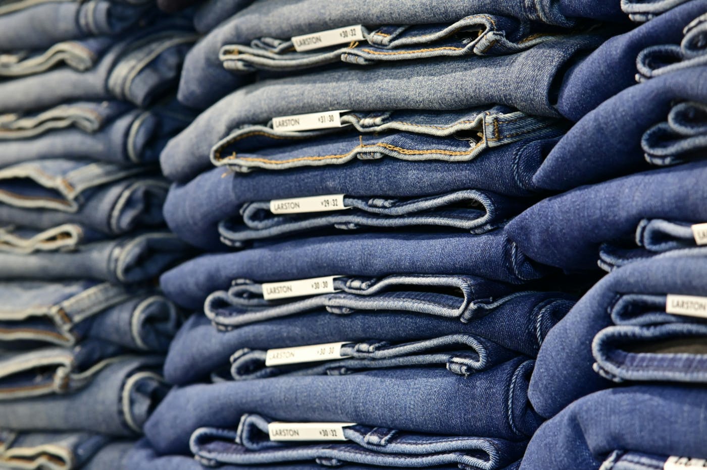 Stacks of neatly folded jeans on a shelf