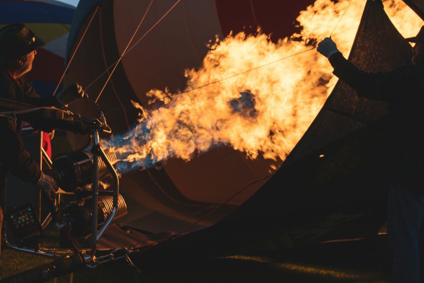 A man heating up the air in a hot air balloon