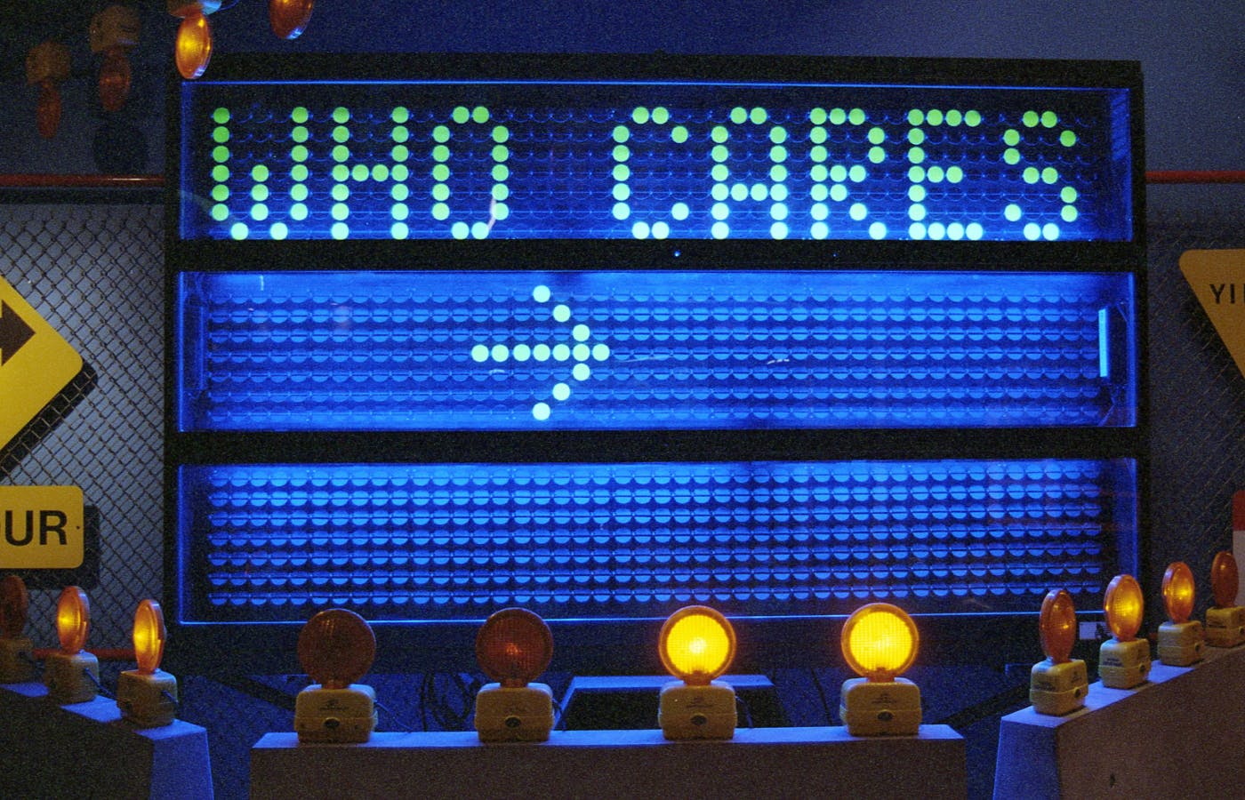 a flashing street sign reading "Who cares"