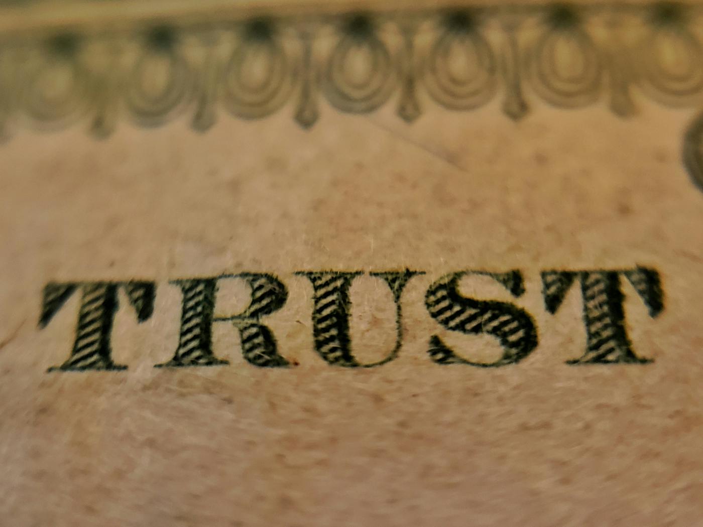 Close up on the word TRUST on a piece of American currency