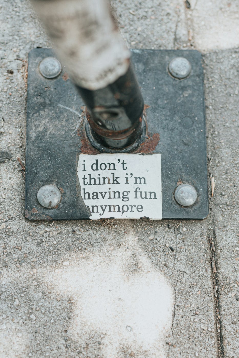 a sticker on the base of a street sign that reads, "I don't think I'm having fun anymore."