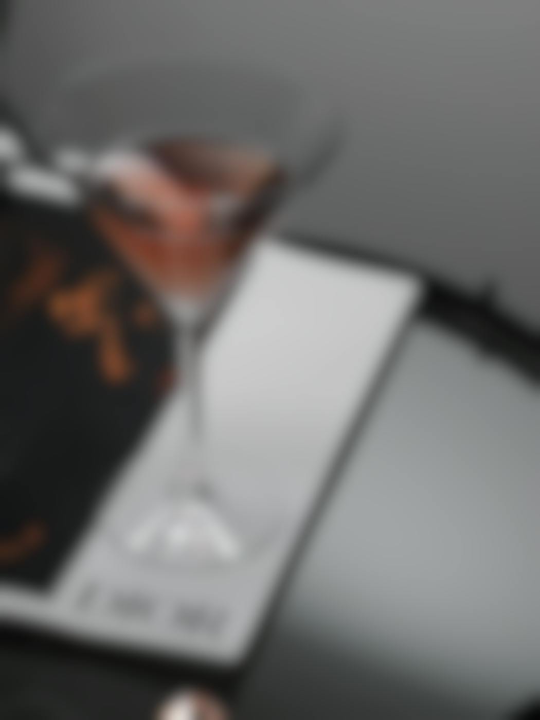 A Cosmo cocktail sitting on a magazine page that reads DIOR