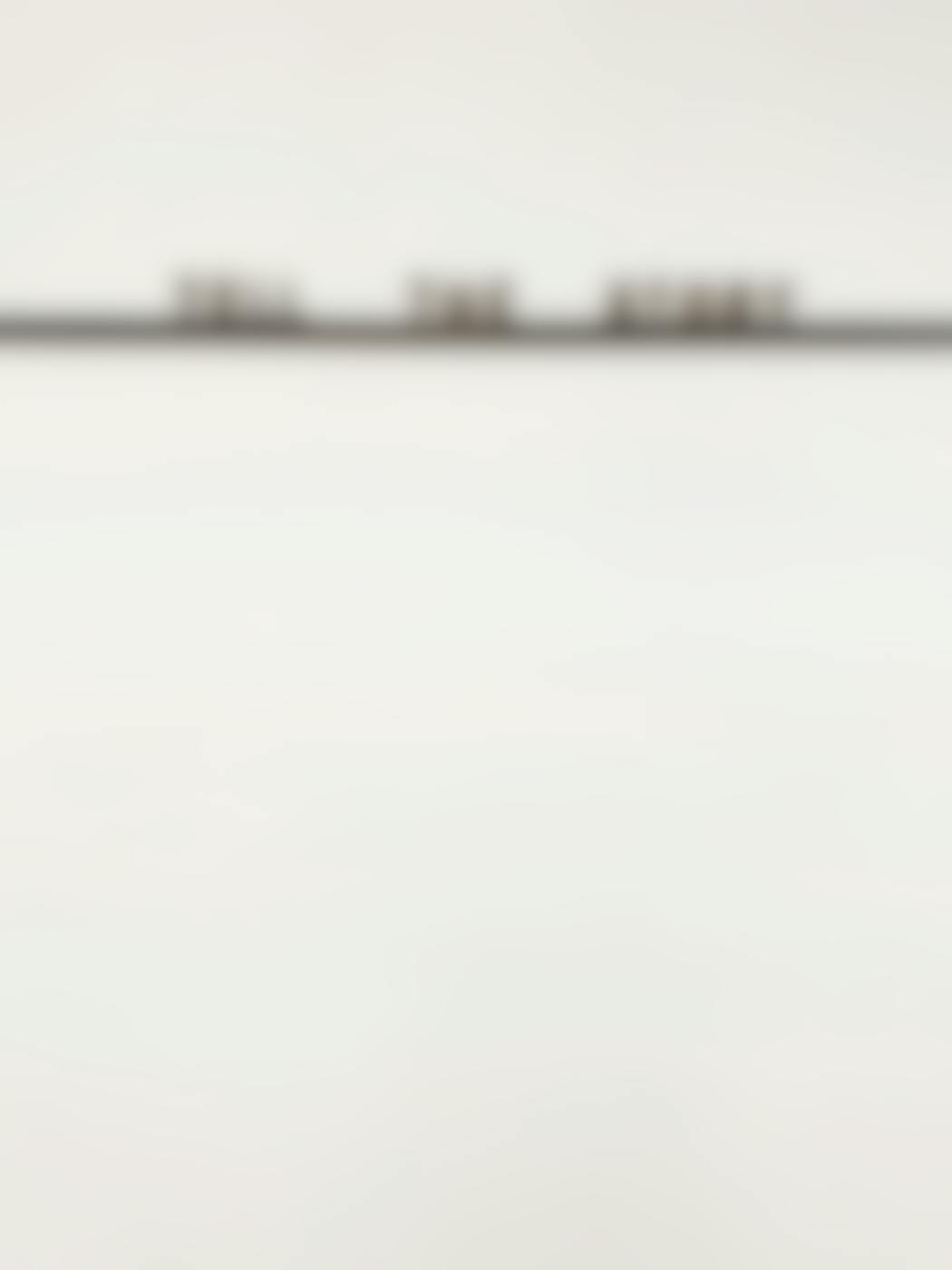 A blank wall with a thin self and the words Tell The Story on the shelf