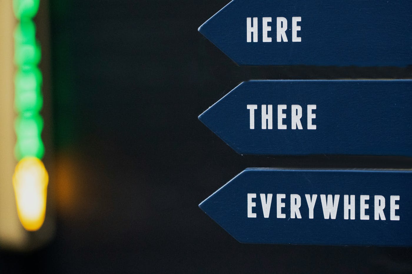 3 blue arrows with white lettering reading here and one reading there and the last reading everywhere