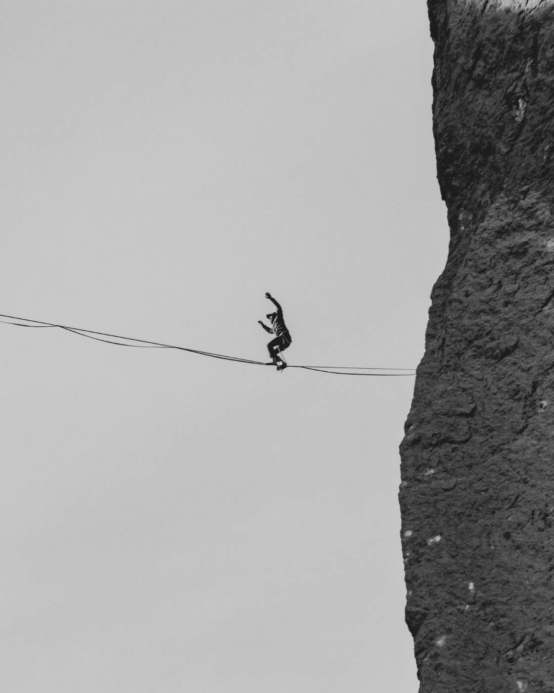 A man on a tightrope off a cliff