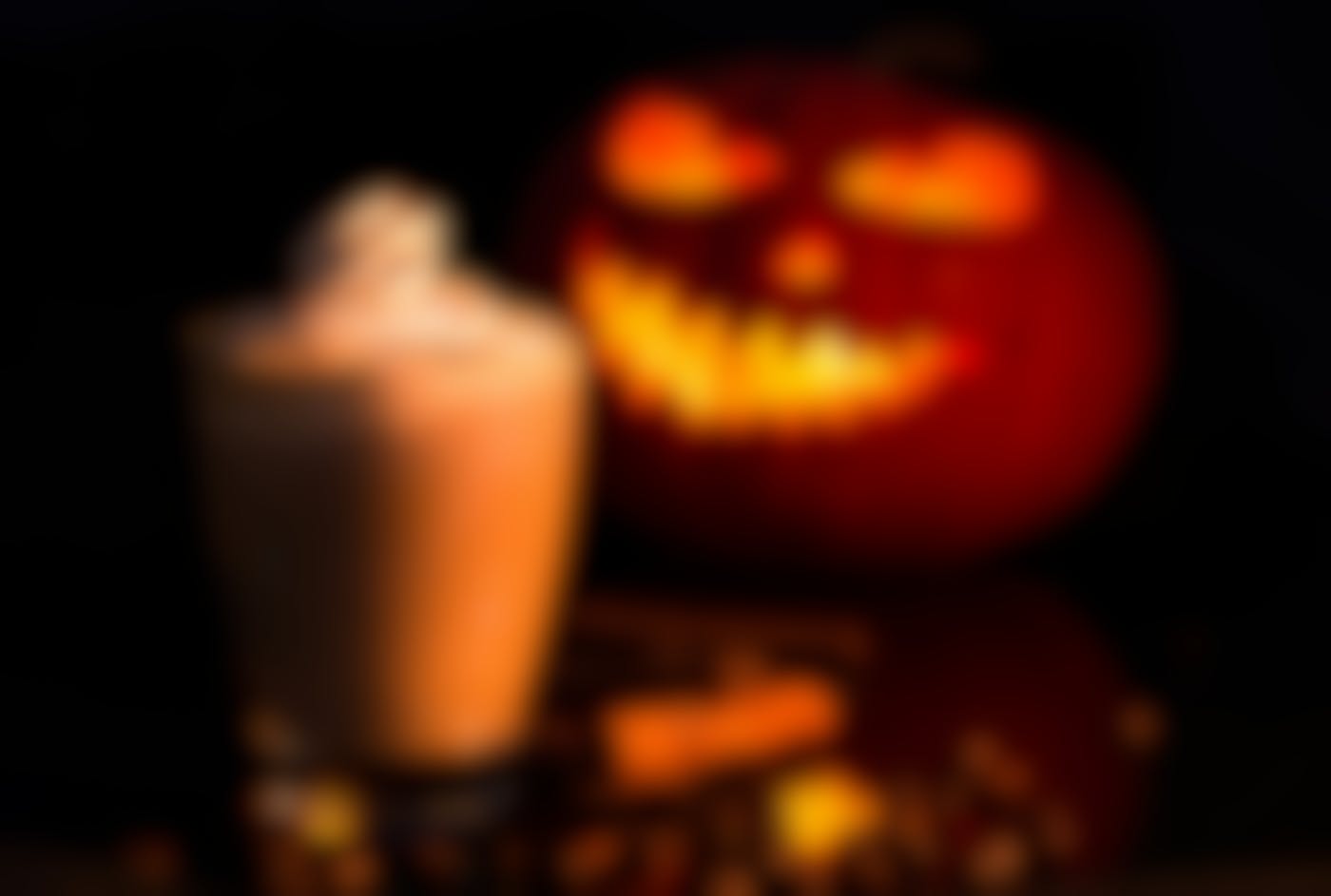 A jack-o-lantern and a pumpkin spiced latte on a table